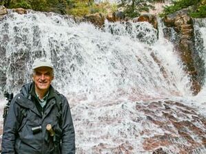 Karl Kroeber stands in front of a waterfall in Zion